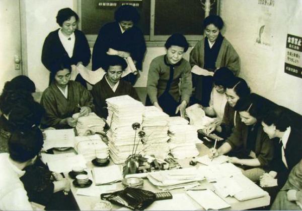 館長室で署名簿を整理する婦人たち