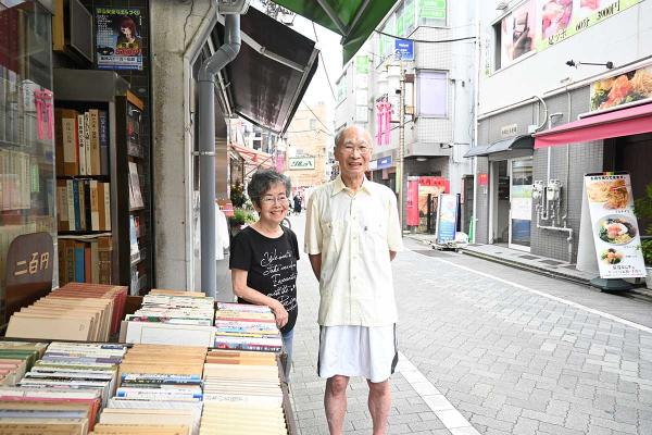 「二百円棚」のある店頭にて。和雄さんと菊栄さん