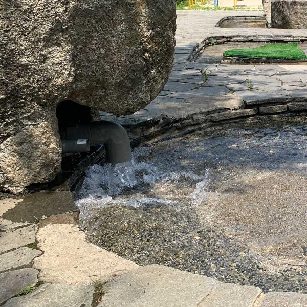 大きな岩から勢いよく水が流れ出ている
