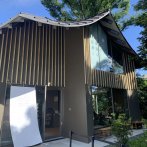 多角形の屋根の向こうには屋敷林の一部が見える
